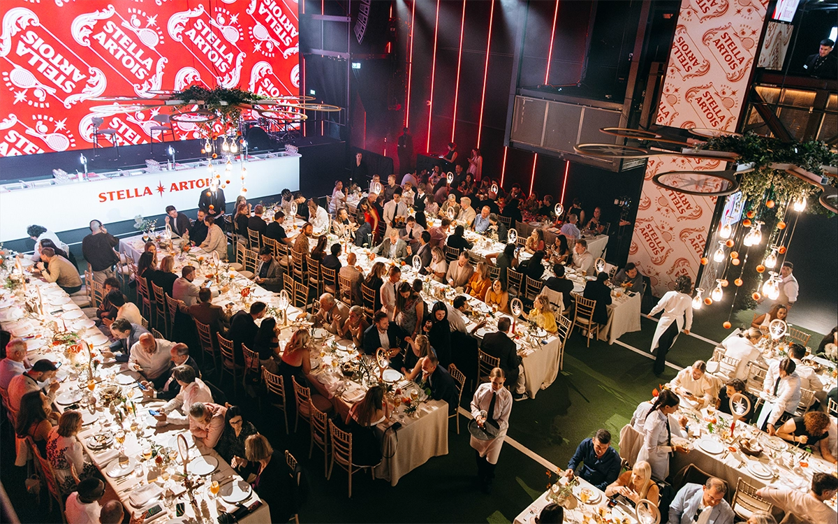 스텔라 아르투아 2025 퍼펙트 서브 어워즈 현장으로 긴테이블에서 생맥주를 즐기는 사람들이 있습니다.